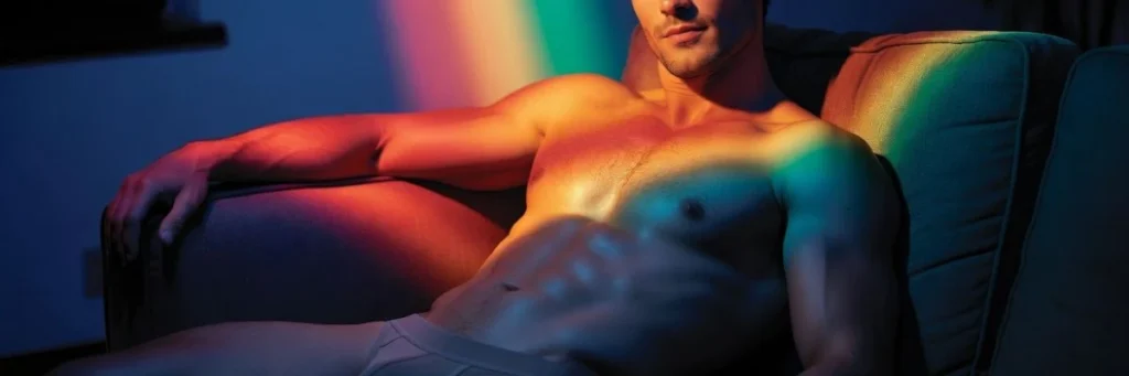 Fit man reclining on a couch in underwear with dramatic lighting